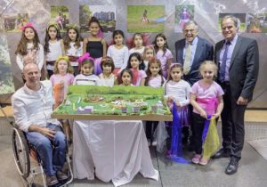 Gruppenfoto mit Kindern und den Herren Jarecki, Würzner und Ritter, davor Modell Kinderbaustelle