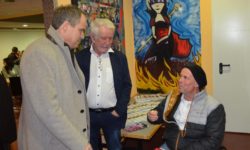 Drei Personen im Bild eine Person sitzt im Rollstuhl